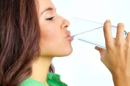 Healthy woman drinking water for it's benefits