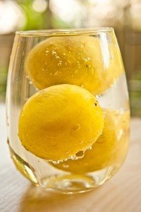 glass of water with whole lemons inside it