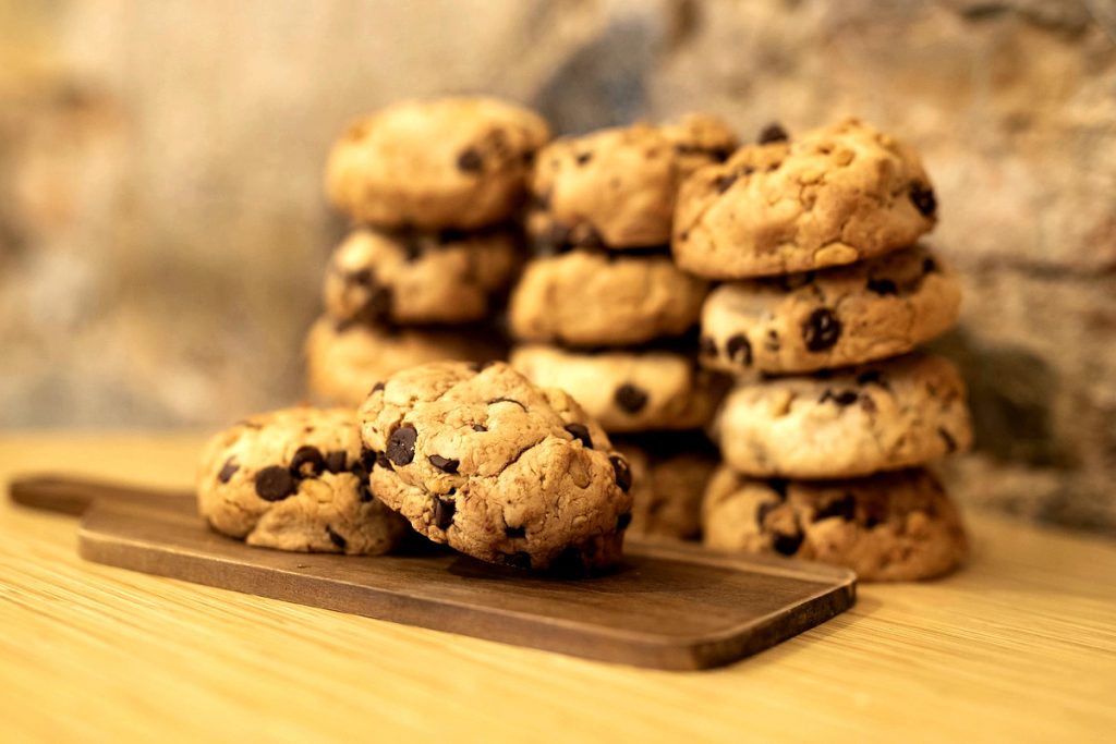 stacks of chocolate chip cookies made with coconut oil instead of shortening on a wooden table